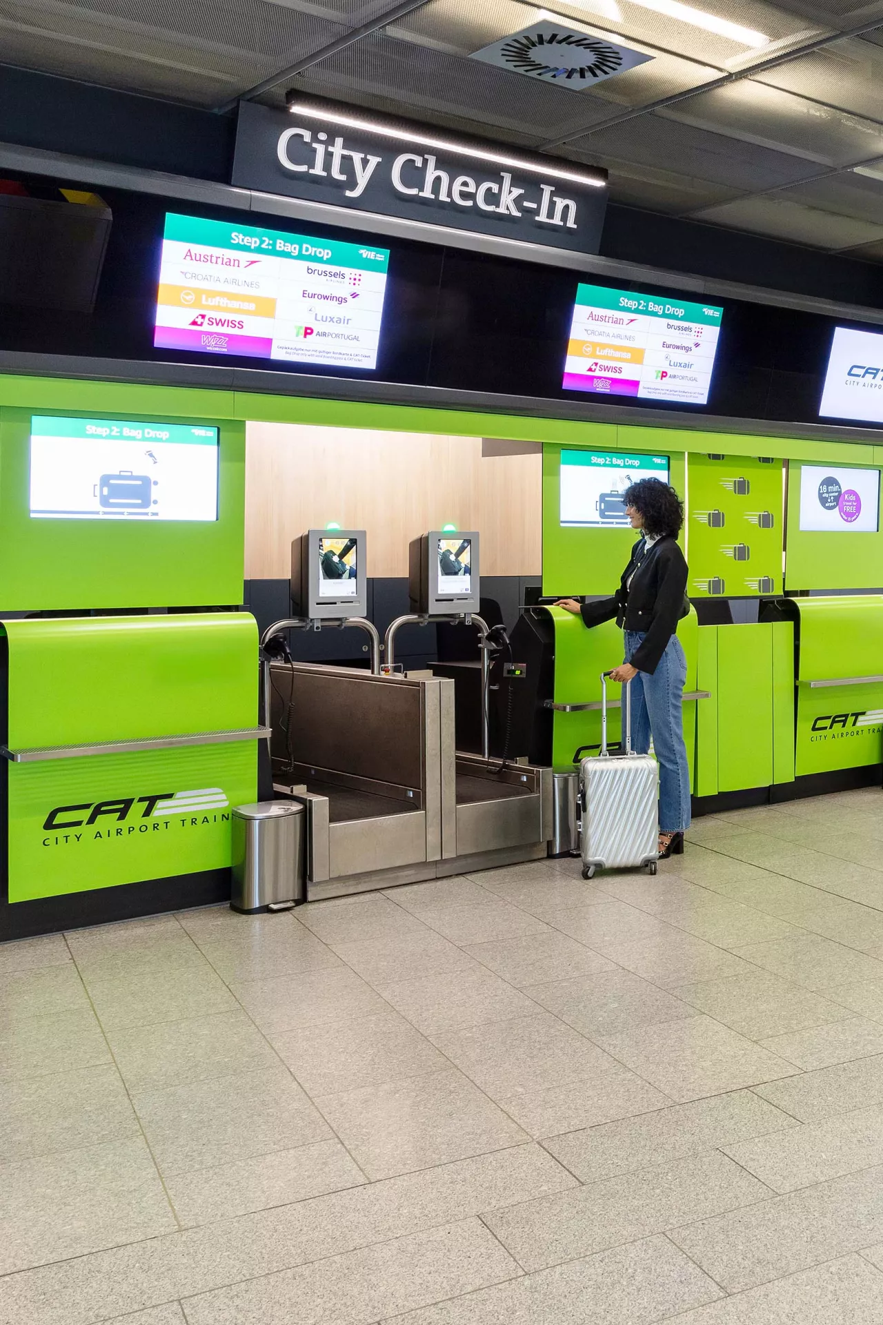 nonstop self bag drop Woman dropping off luggage at the baggage drop station in Wien Mitte