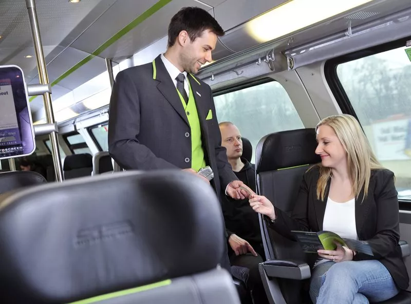 Checking tickets A City Airport Train employee checks a passenger's ticket.
