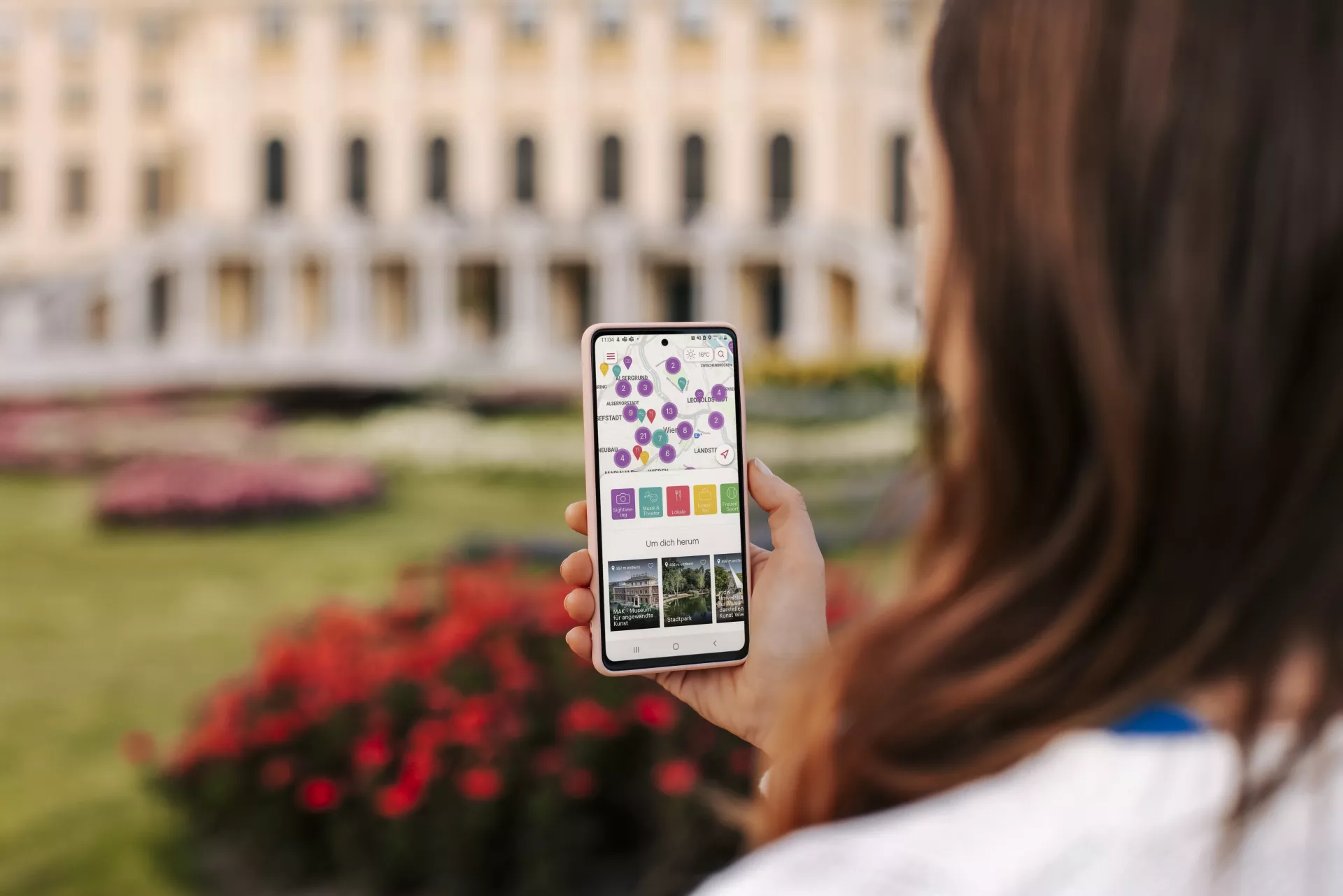 Frau blickt auf ihr Smartphone und verwendet die ivie-App_C-Wien Tourismus_Paul Bauer